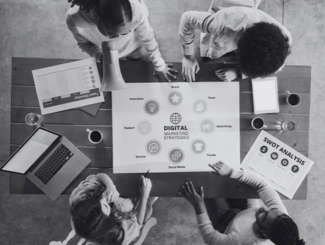 אנשים שיושבים על שולחן ומתכננים אסטרטגיה שיווקית